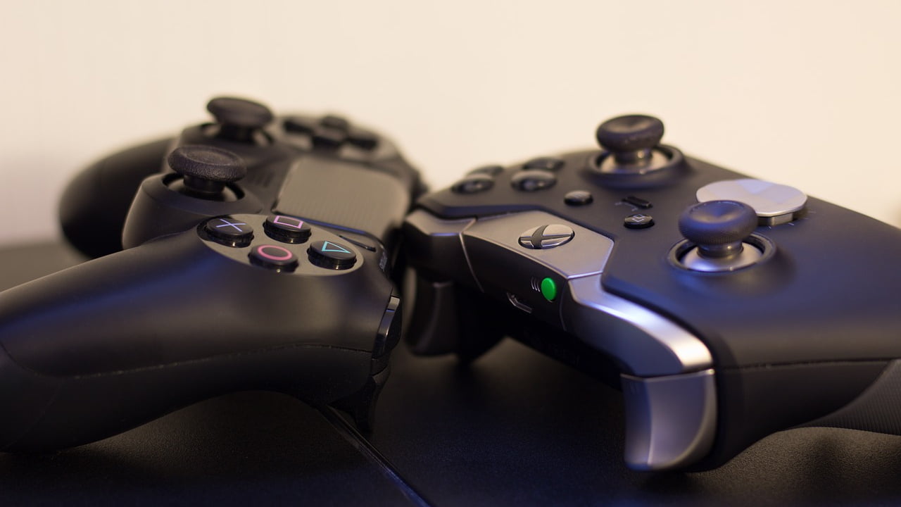 Imagem mostrando um controle de PlayStation 4 e um de Xbox One, ambos consoles de grande sucesso na indústria de games.